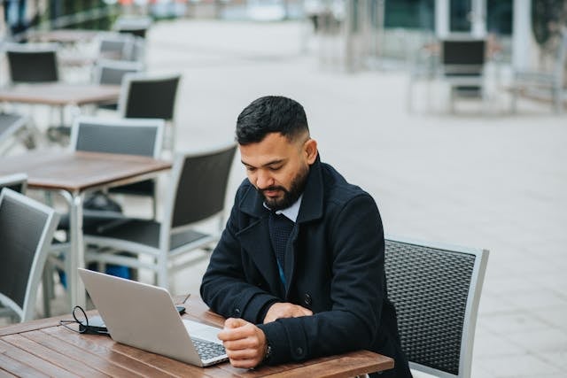 Male in a trench coat having a discussion with someone online